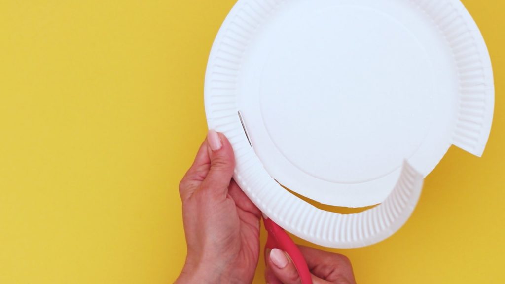 Image showing half of the rim of a paper plate being cut off.