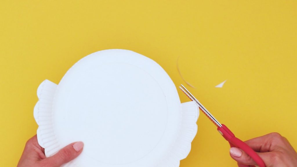 Image showing a pair of scissors cutting a bumpy edge into the remaining rim of the paper plate.