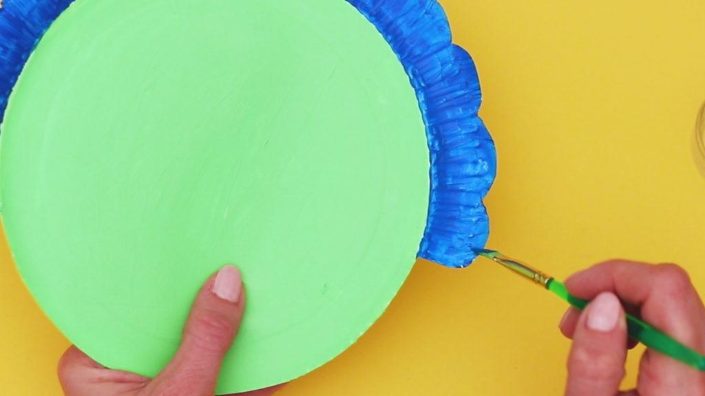 Image showing the paper plate being painted green and blue.