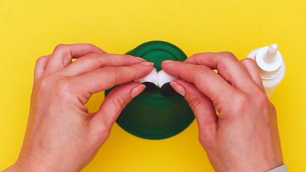 Image showing the two eyes being affixed to the top of the yoghurt pot.