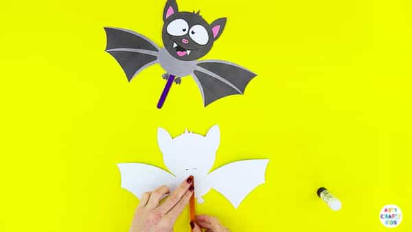 Halloween Crafts for Kids | Complete the paper bat toy with a stick to flap the wings.