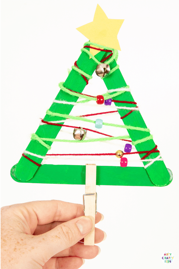 Yarn Wrapped Musical Popsicle Stick Christmas Tree Craft for Kids - Create this easy Christmas Ornament with your kids this Christmas. The Christmas Tree craft doubles up as a jingly musical instrument that will be fun going all day long.