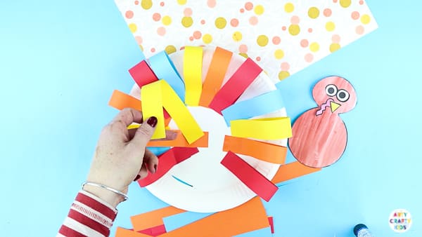 Arty Crafty Kids | Creating a paper plate turkey craft with strips of paper.