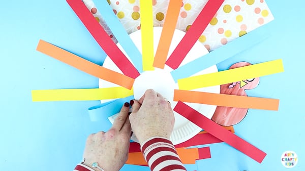Arty Crafty Kids | Creating a paper plate turkey craft with strips of paper.