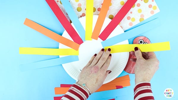 Arty Crafty Kids | Creating a paper plate turkey craft with strips of paper.