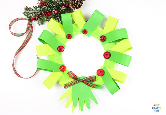 Easy Paper Plate Handprint Christmas Wreath Craft for kids. A n easy Christmas craft that kids will love to make either at home or within the classroom. With added handprints, this craft also doubles up as a special keepsake craft for the festive season.