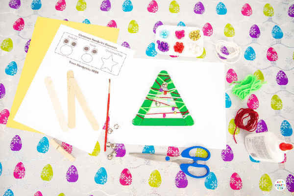 Yarn Wrapped Musical Popsicle Stick Christmas Tree Craft for Kids - Create this easy Christmas Ornament with your kids this Christmas. The Christmas Tree craft doubles up as a jingly musical instrument that will be fun going all day long.