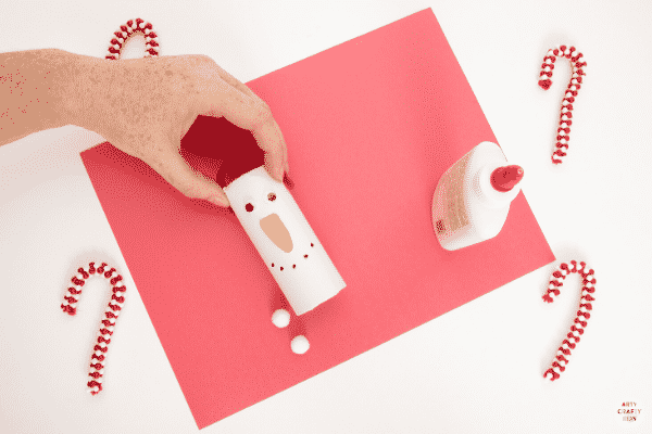 Add ear muffs to the paper roll snowman.