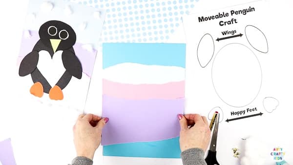 Interactive Paper Penguin Craft - Inspired by Happy Feet. A fun and engaging Winter craft for Kids. With a penguin that moves and dances on the snowy floor, this is a craft that inspires children to play!