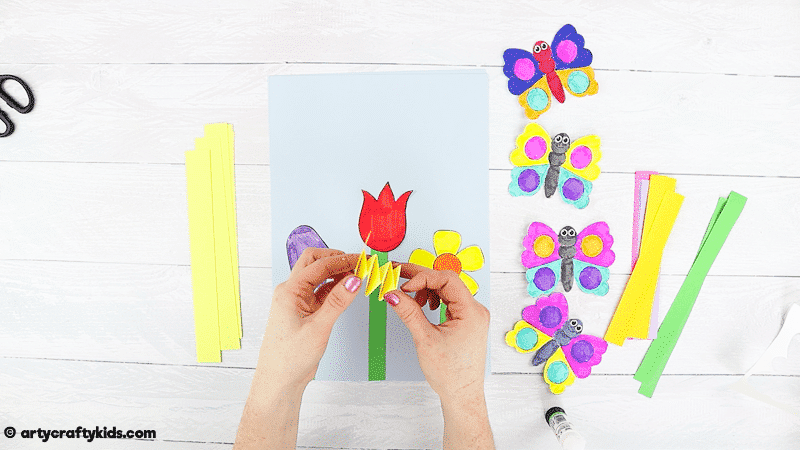 Make a Bobble Butterfly Craft with Spring Flowers with the Kids.  A fun and easy Spring craft that kids will love. The butterfly craft can be completed with our printable butterfly template.