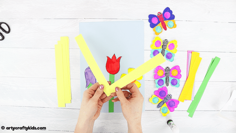 Make a Bobble Butterfly Craft with Spring Flowers with the Kids.  A fun and easy Spring craft that kids will love. The butterfly craft can be completed with our printable butterfly template.