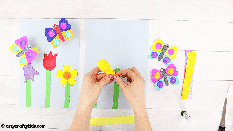 Make a Bobble Butterfly Craft with Spring Flowers with the Kids.  A fun and easy Spring craft that kids will love. The butterfly craft can be completed with our printable butterfly template.