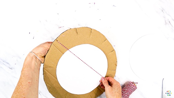 Add a circular piece of white cardstock and begin threading across in a clock formation.