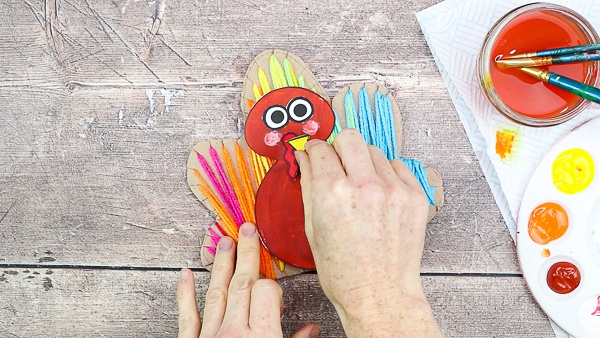 Add facial features to the turkey to complete the yarn wrapped Turkey craft.