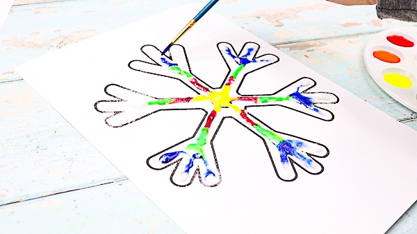 Continue painting the snowflake to transform it into a rainbow snowflake.