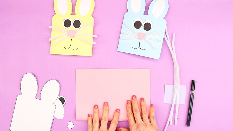 Image showing cut out Easter Bunny Card elements and hands folding a sheet of cardstock.