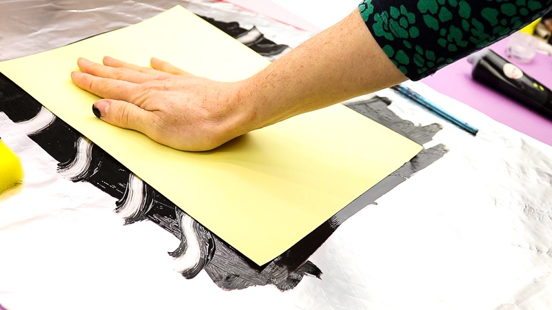 Image showing a piece of card being placed down onto the print.