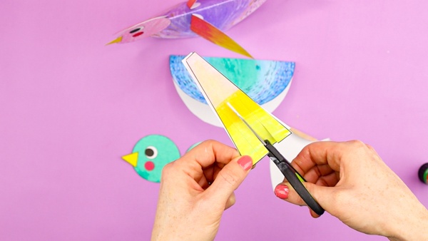 Image showing scissors cutting along lines of the paper birds tail feathers.
