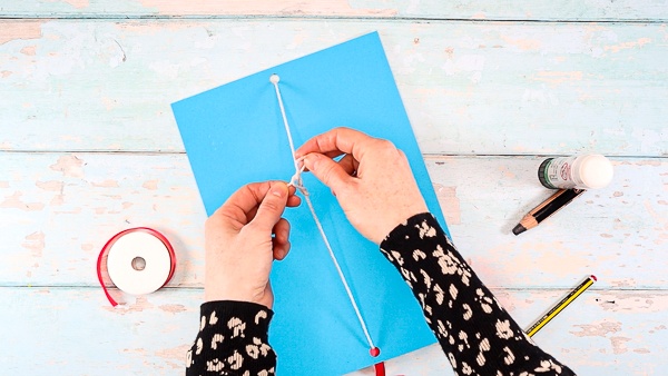 Image showing the string that's attached to the 3D kite thread through the two holes.