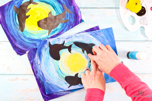 Explore the deep dark ocean with our Easy Shark Art project for kids and Printable Shark Silhouettes, using the scrape painting technique to create an under the sea background.