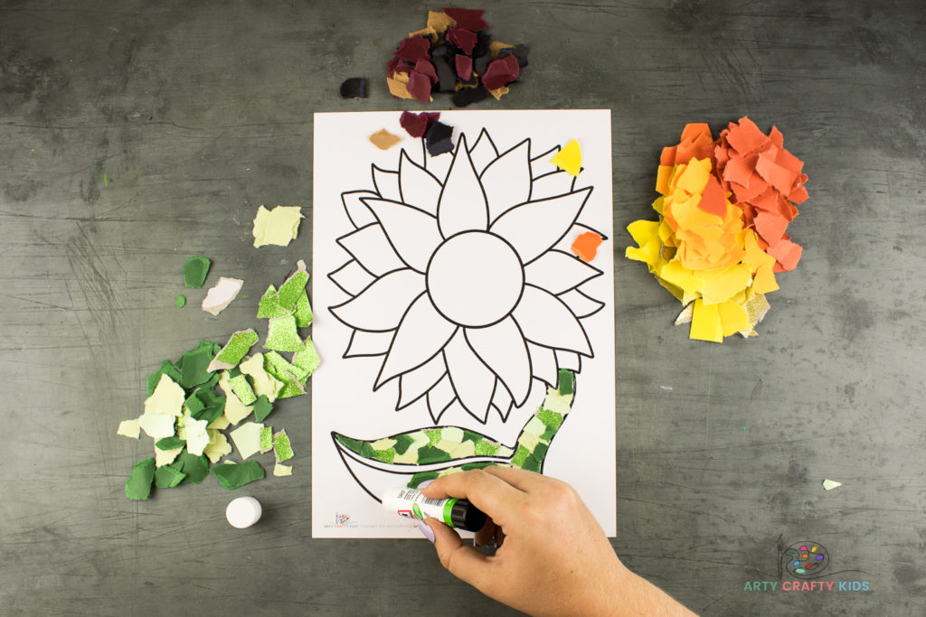 Image showing glue being applied to the leaf of the sunflower template.