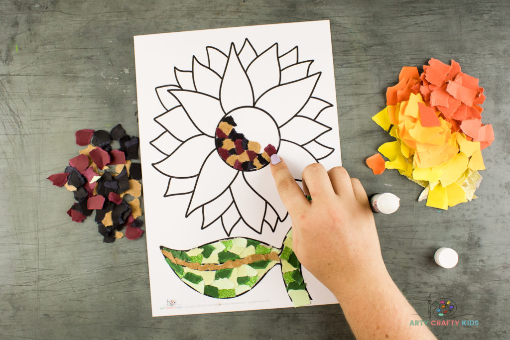 Image showing a small piece of brown paper being stuck to the centre of the sunflower.