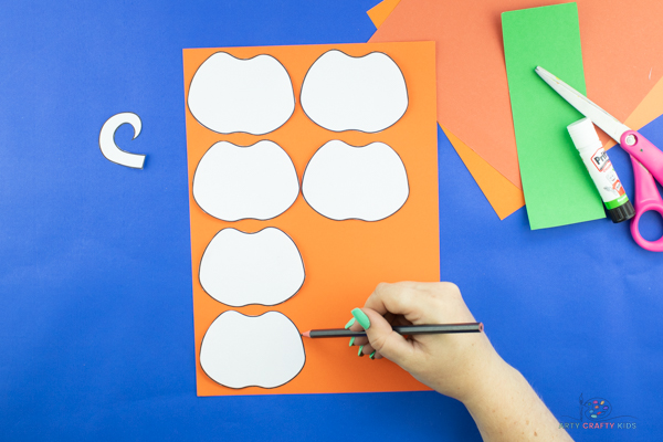 Image showing 6 cut out paper pumpkin craft elements from the template and traced onto orange cardstock.