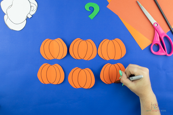 Image showing black curved lines drawn onto each pumpkin.