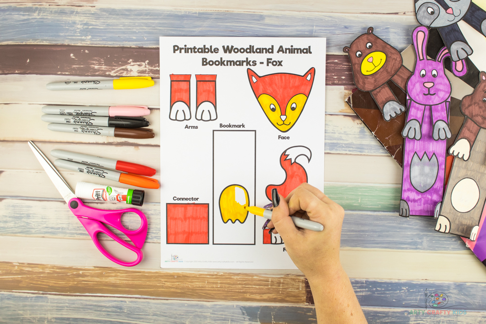 Image shows the Printable Woodland Animal Bookmark - Fox template, being colored in with bright orange and yellow marker pen.