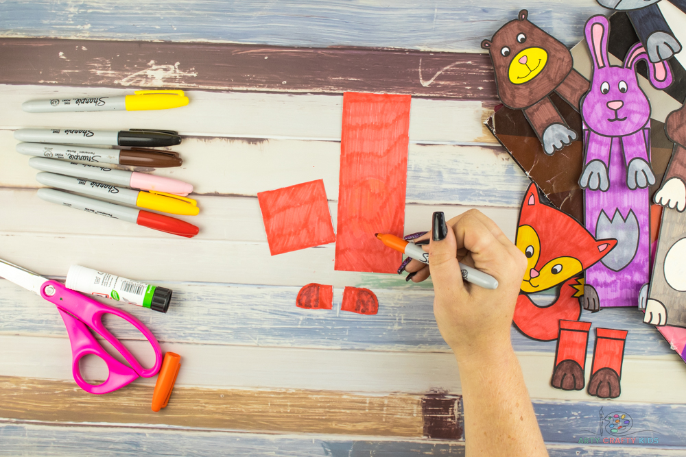 Image shows the back of the main bookmark element being colored in with bright orange marker pen.