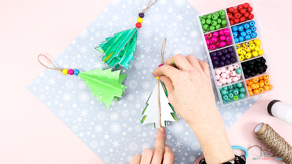 Image showing the Christmas tree bauble opened up and flattened on the surface with the piece of string placed along it's center.