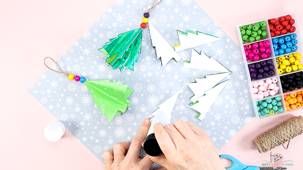 Image showing a hand applying glue to one side of the folded Christmas tree.