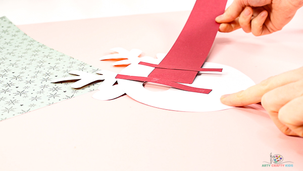 Image showing hands sliding the largest paper strip underneath the supporting paper strips.