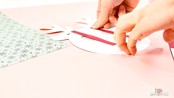 Image showing hands affixing the supporting paper strips to the back of the reindeers head.