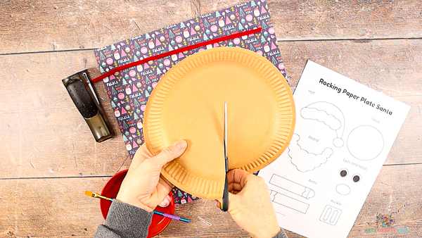 Image showing hands cutting into a paper plate to the half way point. 