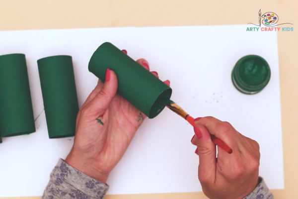 Image showing hands painting 5 paper rolls green.