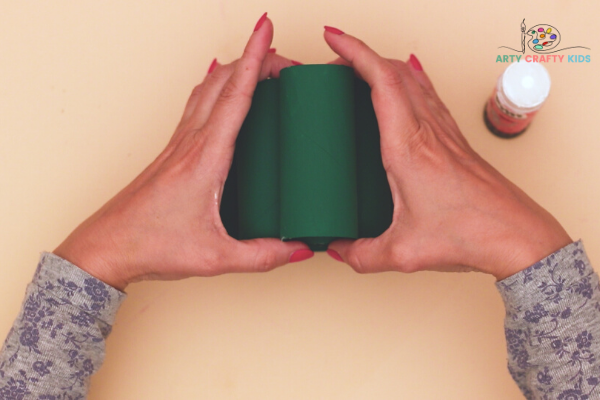Image showing hands layering the remaining green rolls to form a pyramid - Christmas tree shape.