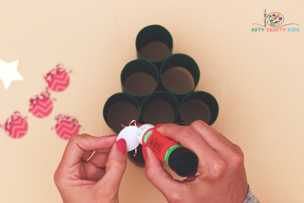 Image showing hands applying glue to the back of bauble.