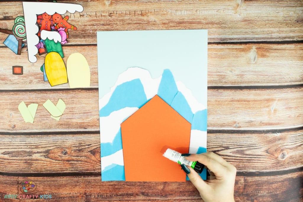 Image showing glue being applied to the house element to be glued on to the background.