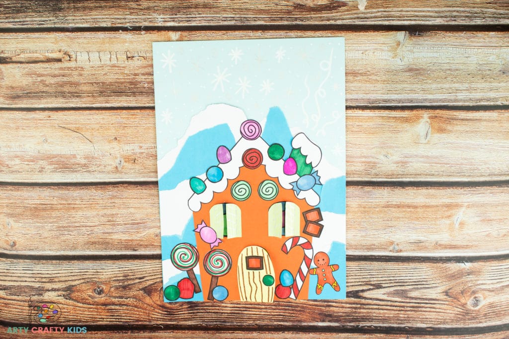 Image showing the complete gingerbread house with lots of candy stuck on and snowflakes drawn on the background.