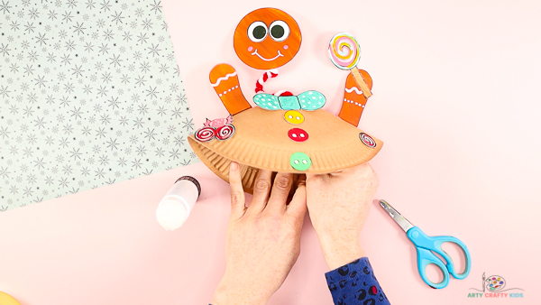 Image showing hands inside the paper plate securing the pipe cleaner.