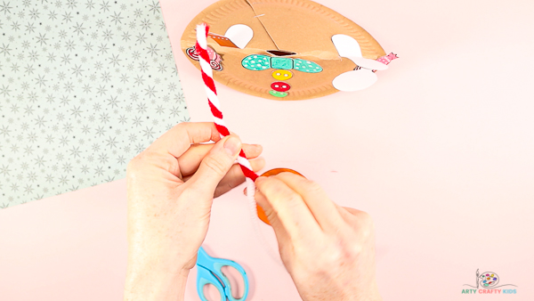 Image showing hands twisting a white and red pipe cleaner around each other to form one.