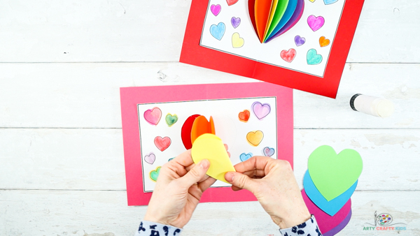 Image showing hands folding a yellow heart shape.