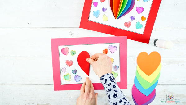 Image showing hands glueing a folded heart to the inside of the folded backing card.