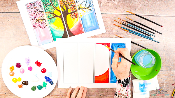 Image showing hands painting the second rectangle orange and red, leaving a semi circle white in the middle.