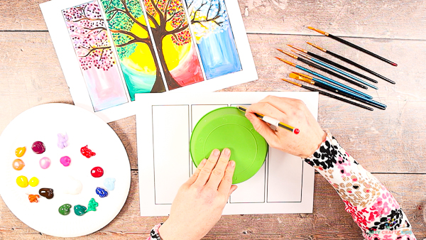 Four Seasons Tree Painting: Image showing a hand drawing around a bowl on the four framed template.