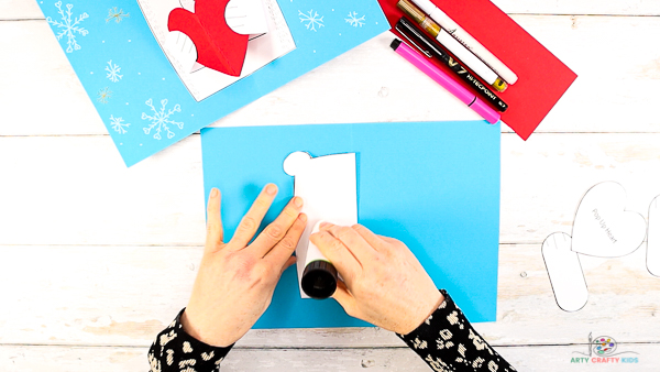 Image showing hands applying glue with a glue stick to one side the polar bear. 