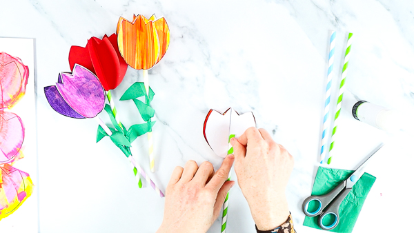 Image showing hands gluing the straw to the inside of the folded tulips.