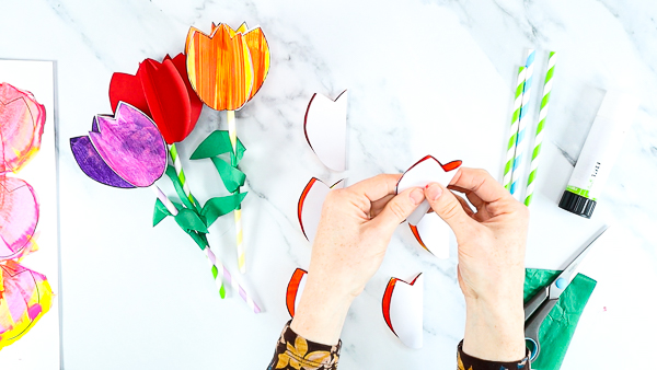 Image showing hands folding each of the tulip heads in half.