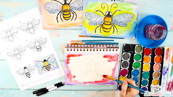 Image showing hands painting the surround of the bee pink and red.